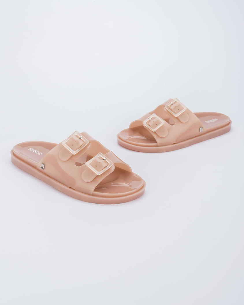 Angled view of a pair of Melissa Wide slide sandals in pink with two front straps