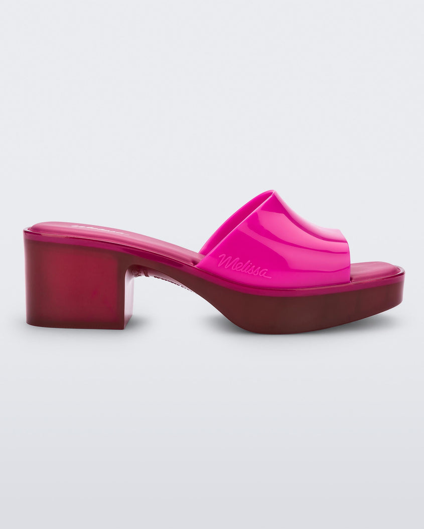 Side view of a Melissa Shape slide with transparent pink platform heel and a hot pink wide front strap. 