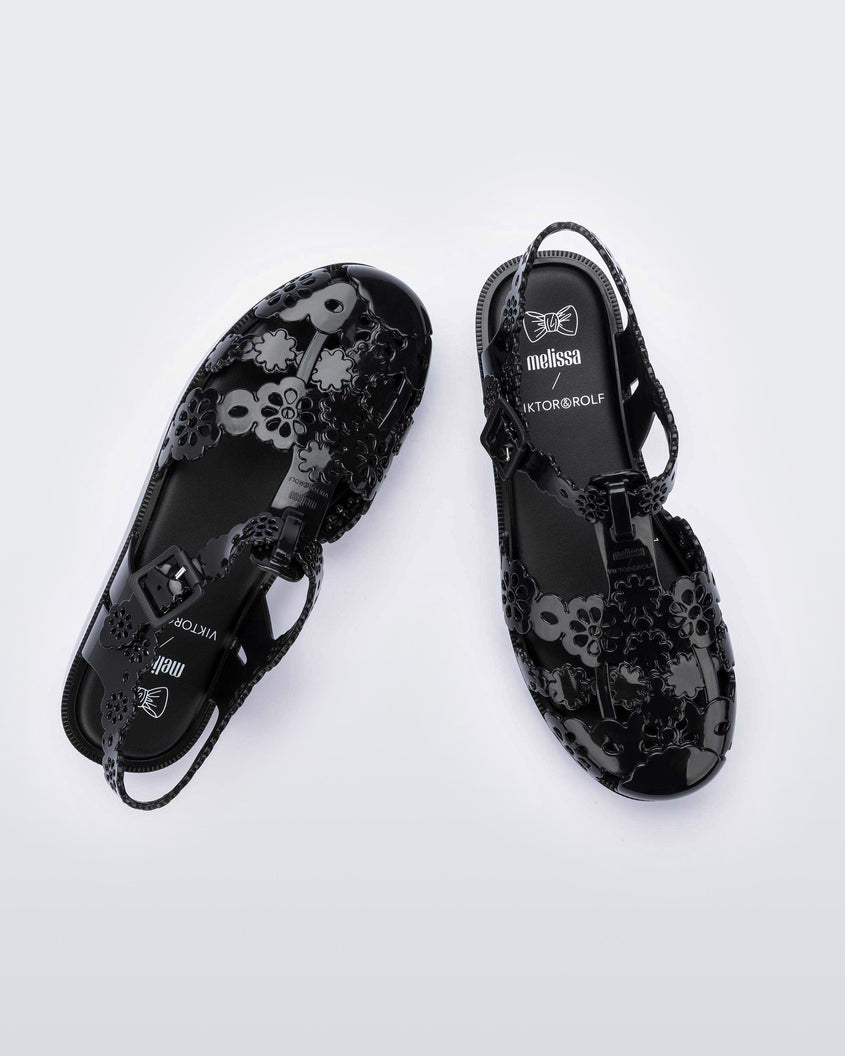 Top view of a pair of Melissa Possession fisherman sandals in black with cut out lace detail on the straps.
