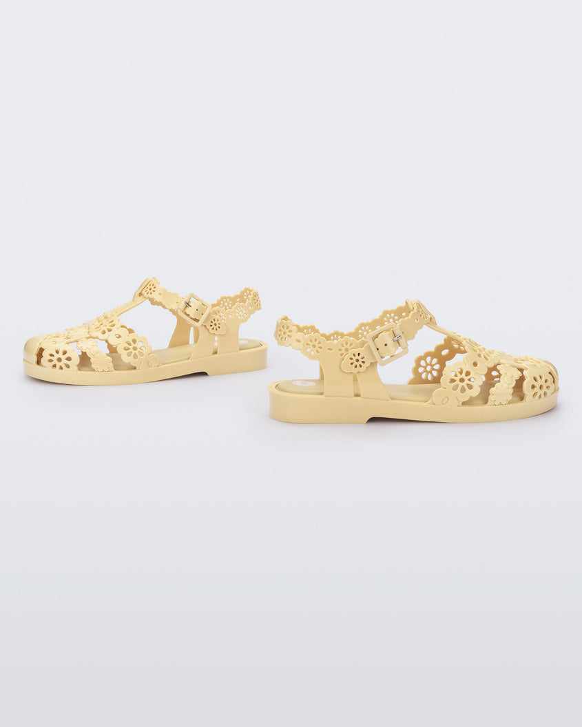 Side view of a pair of Melissa Possession fisherman sandals in yellow with cut out lace detail on the straps.