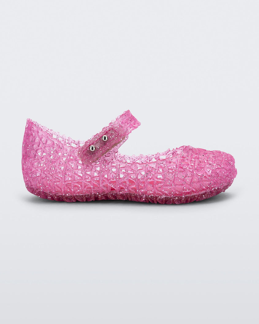 Side view of Mini Melissa Campana pink glitter flats with a snap strap for baby with an open woven texture