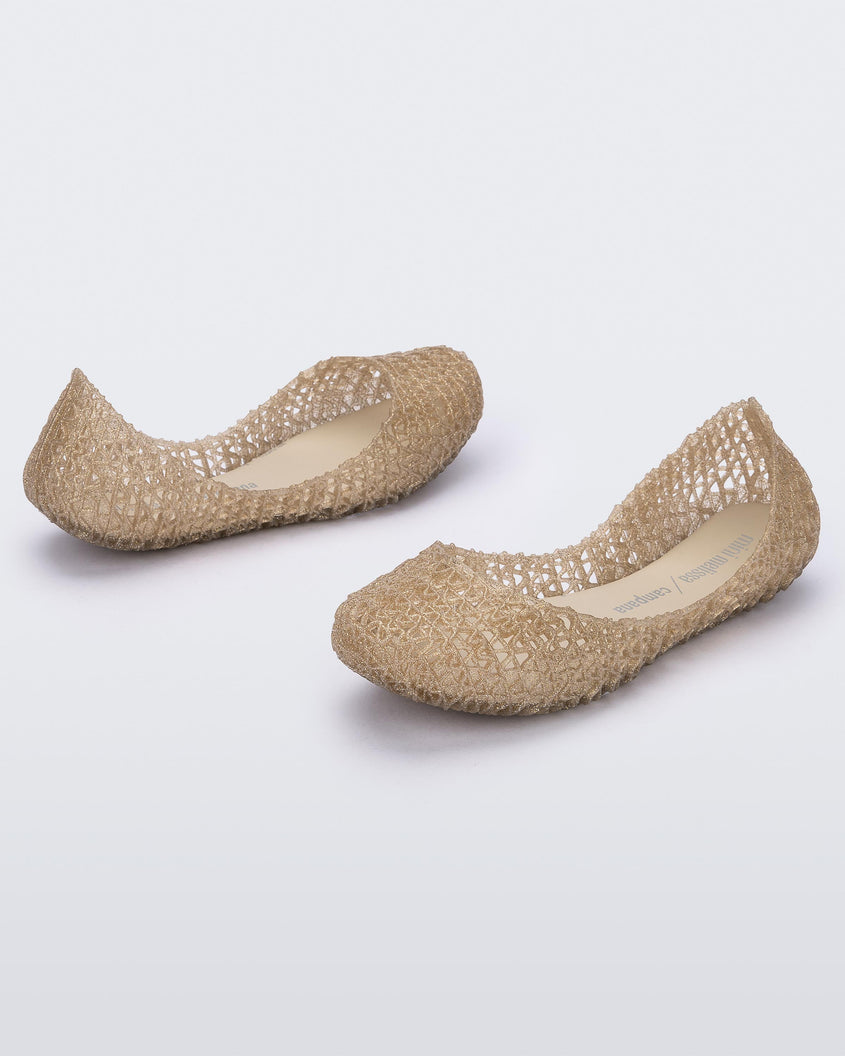 An angled side and back view of a pair of Beige/Glitter Mini Melissa Campana flats with a woven detail base.