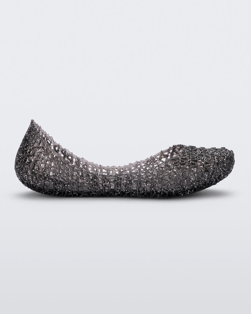 Side view of a black Mini Melissa Campana flat with a glitter design and an open woven texture.