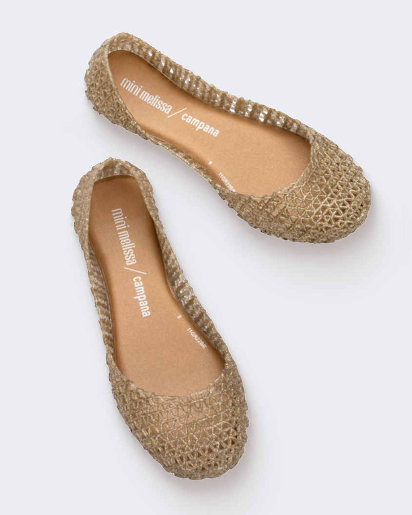 Top view of a pair of gold glitter Mini Melissa Campana flats with a woven detail base.