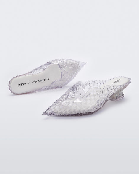 An angled front and top view of a pair of clear white Melissa Court heels with a heart detail on the front and a checkered pattern texture.