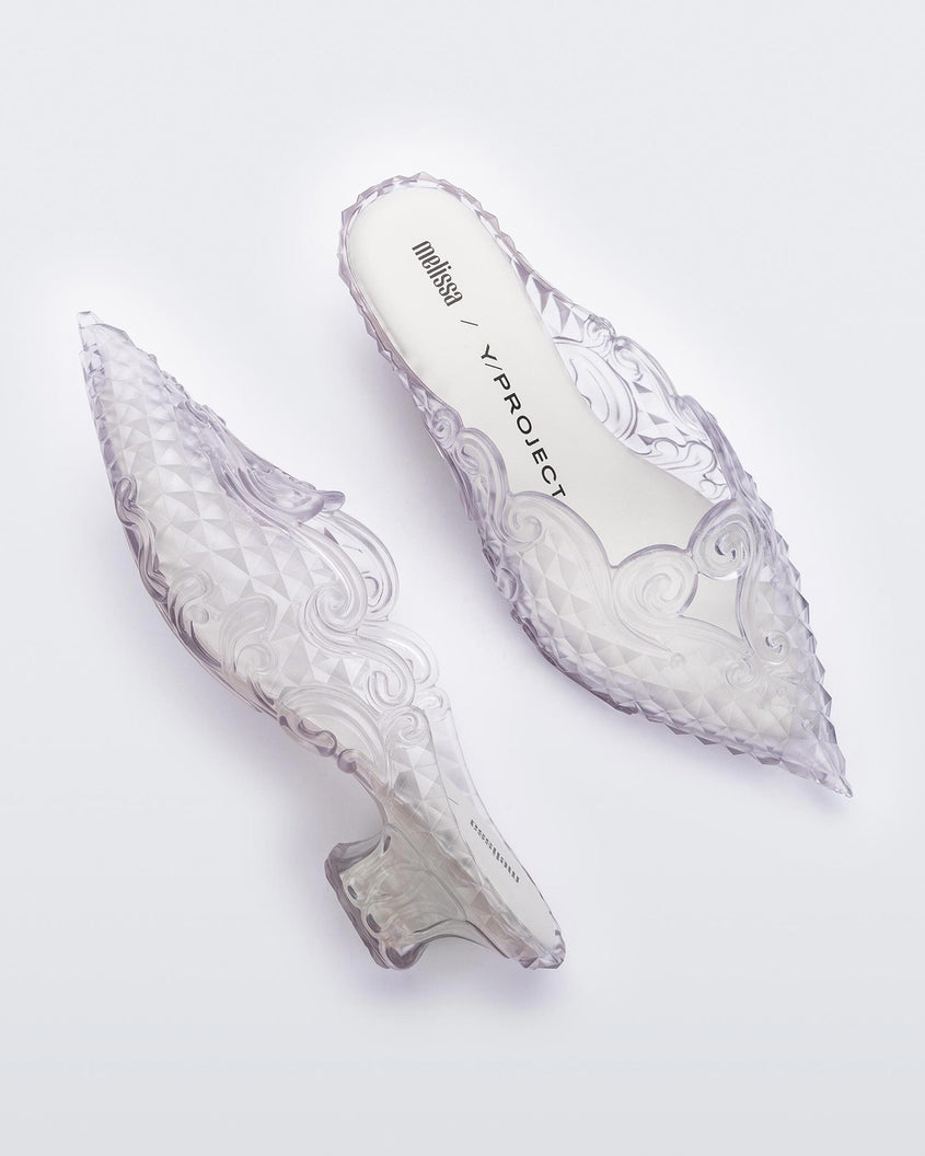 A side and top view of a pair of clear white Melissa Court heels with a heart detail on the front and a checkered pattern texture.