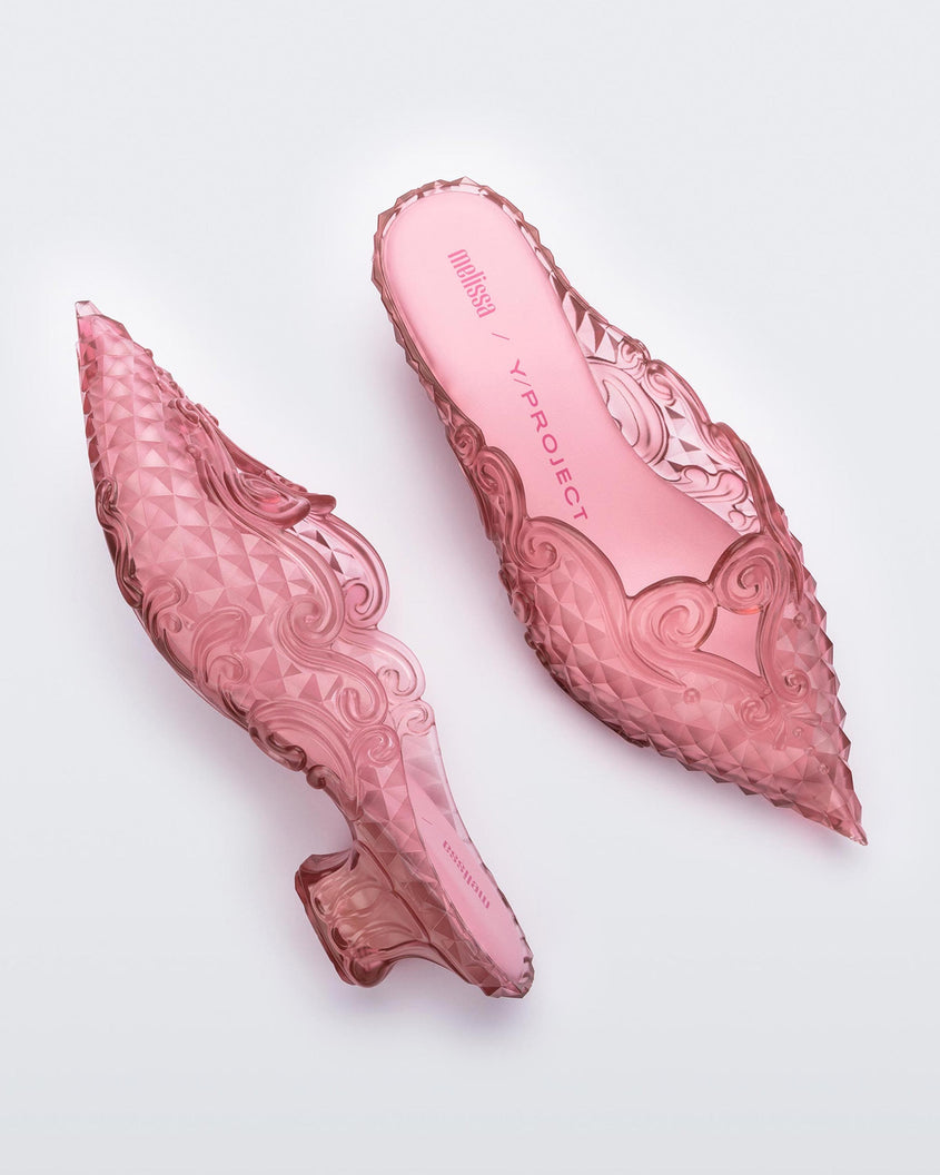 A top and side view of a pair of transparent pink Melissa Court heels with a heart detail on the front and a checkered pattern texture.