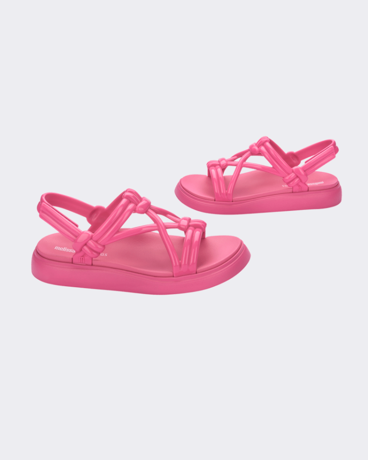Side view of a pair of Melissa Papete Essential pink sandals with straps.