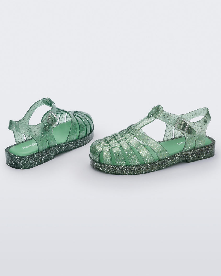 Side and back view of a pair of Green/Glitter/Silver Mini Melissa Possession sandals with several straps and a green glitter base.