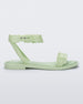 Side view of a Melissa Wave Blossom sandal in Green with floral design ankle and front straps and double snap closure 