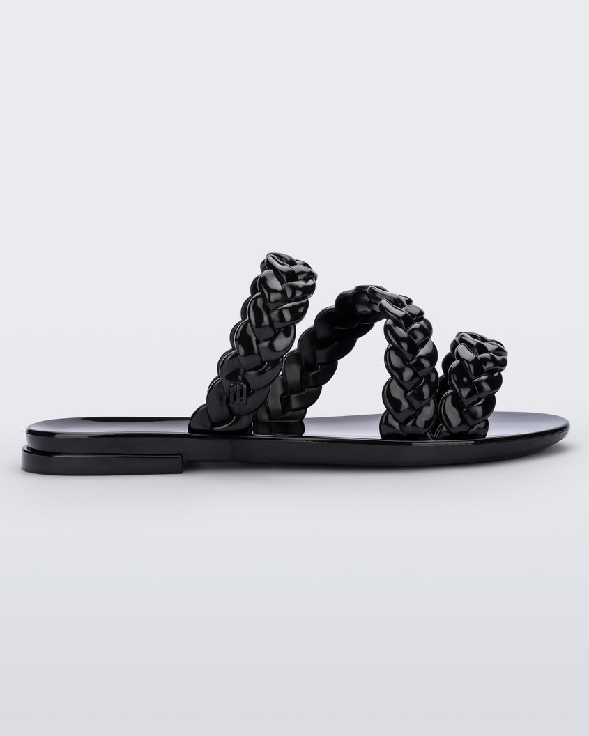 Side view of a black Melissa Wrap slide with 3 braid like straps.