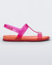 Side view of a pink / orange Melissa Adore sandal with two translucent pink straps, joined together by a third strap and an orange insole.