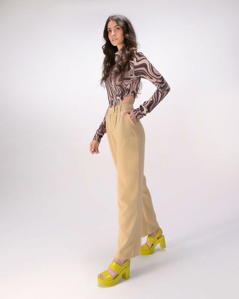 A model in beige pants wearing a pair of green Melissa Mule heel platform Sandals.