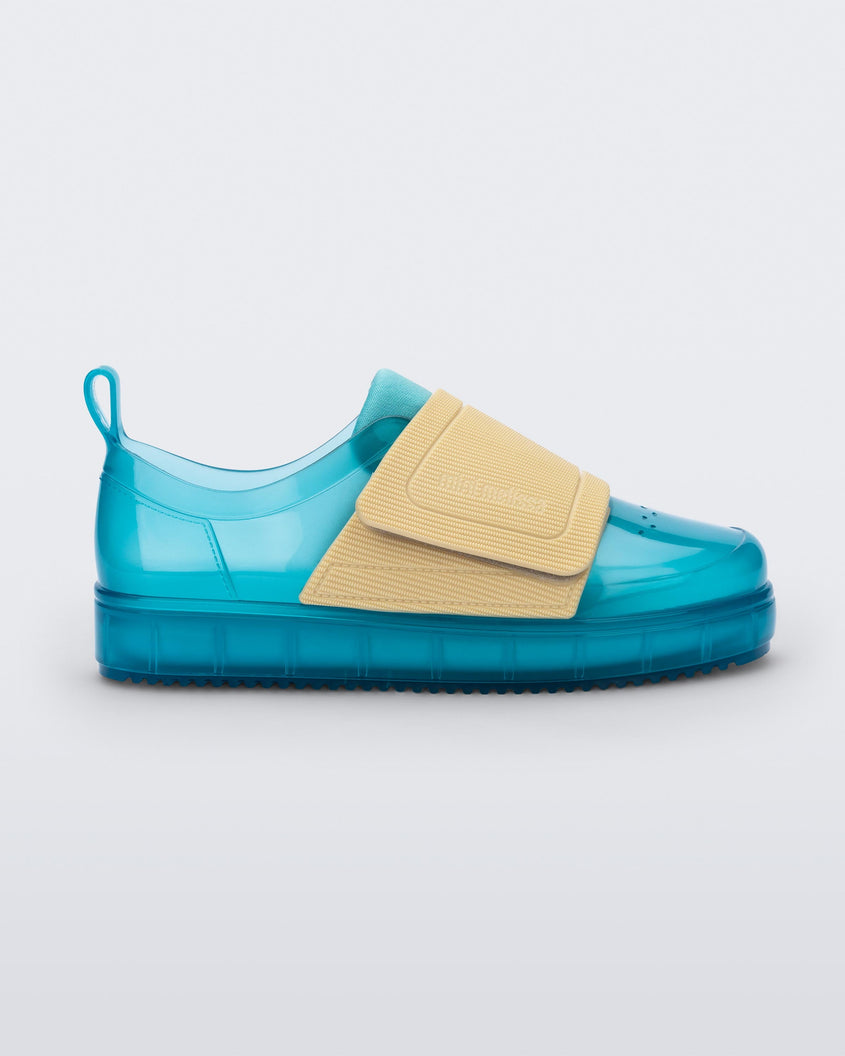 Side view of a pair of blue/yellow Mini Melissa Jelly Pop Sneakers with a blue base and a yellow velcro strap.