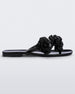 Side view of a black Melissa Harmomic Squared Garden flip flop with flowers on the straps.