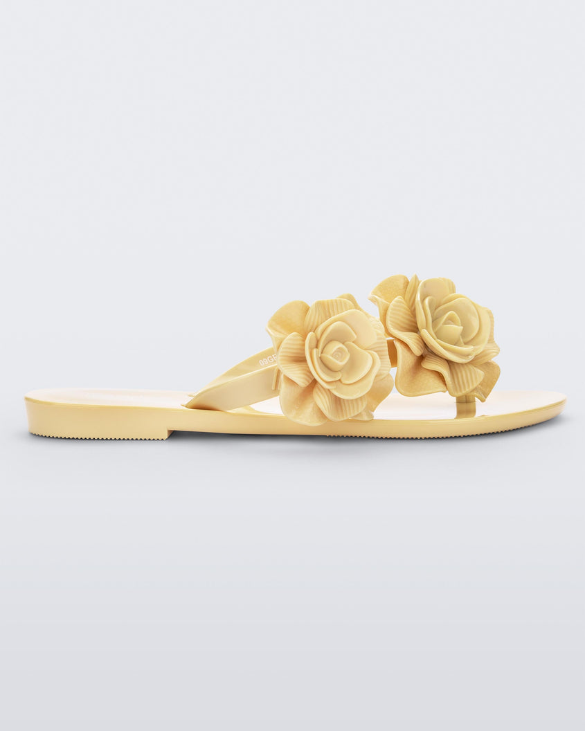 Side view of a yellow Melissa Harmonic Garden flip flop with flowers on the straps.