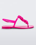 Side view of a pink Melissa Harmonic Squared Garden sandal with a flower decoration on the front strap.