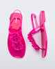 A top and side view of a pair of pink Melissa Harmonic Squared Garden sandals with flower decorations on the front straps.