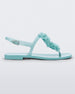 Side view of a green Melissa Harmonic Squared Garden sandal with a flower decoration on the front strap.