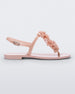 Side view of a light pink Melissa Harmonic Squared Garden sandal with a flower decoration on the front strap.