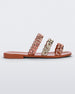 Side view of a pair of orange Melissa Feel slides with three orange and gold chain detail straps.