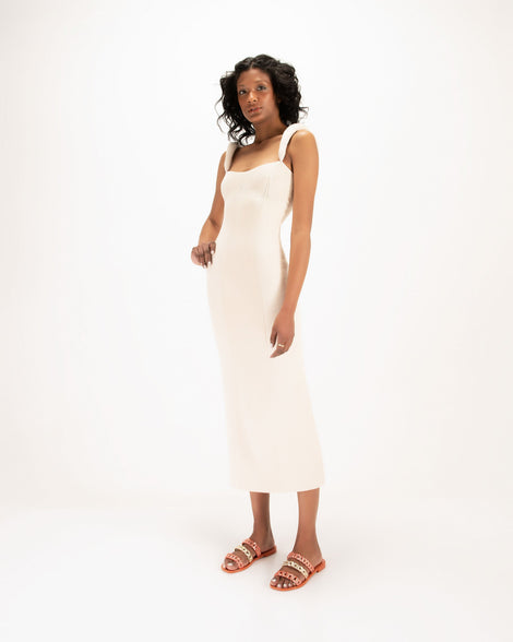 A model posing for a picture wearing a pair of orange Melissa Feel slides three gold and orange chain detail straps.