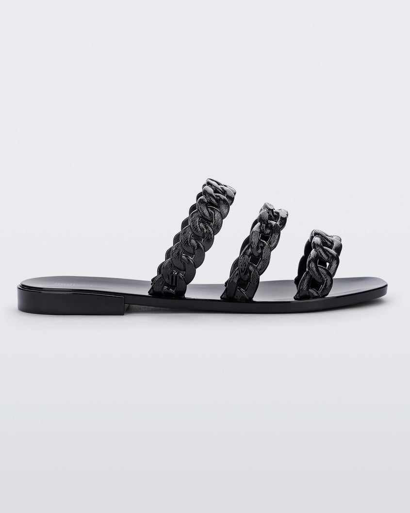 Side view of a black Melissa Feel slide with three chain detail straps.
