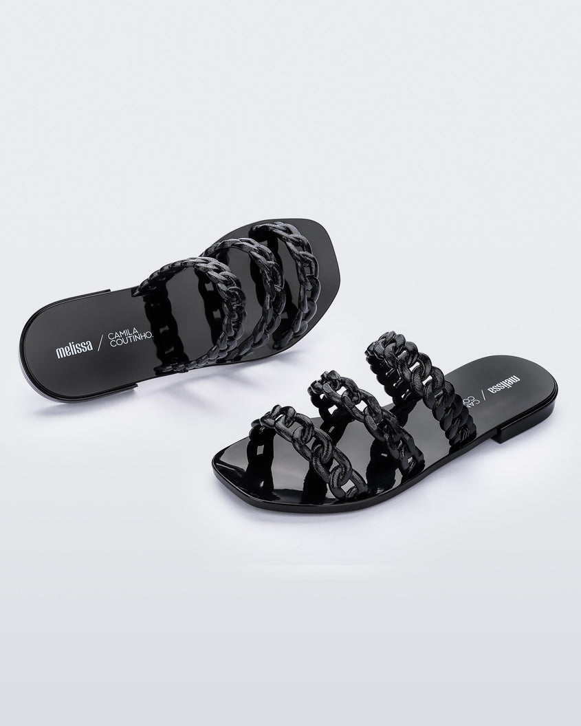 Top and angled side view of a pair of black Melissa Feel slides with three chain detail straps.