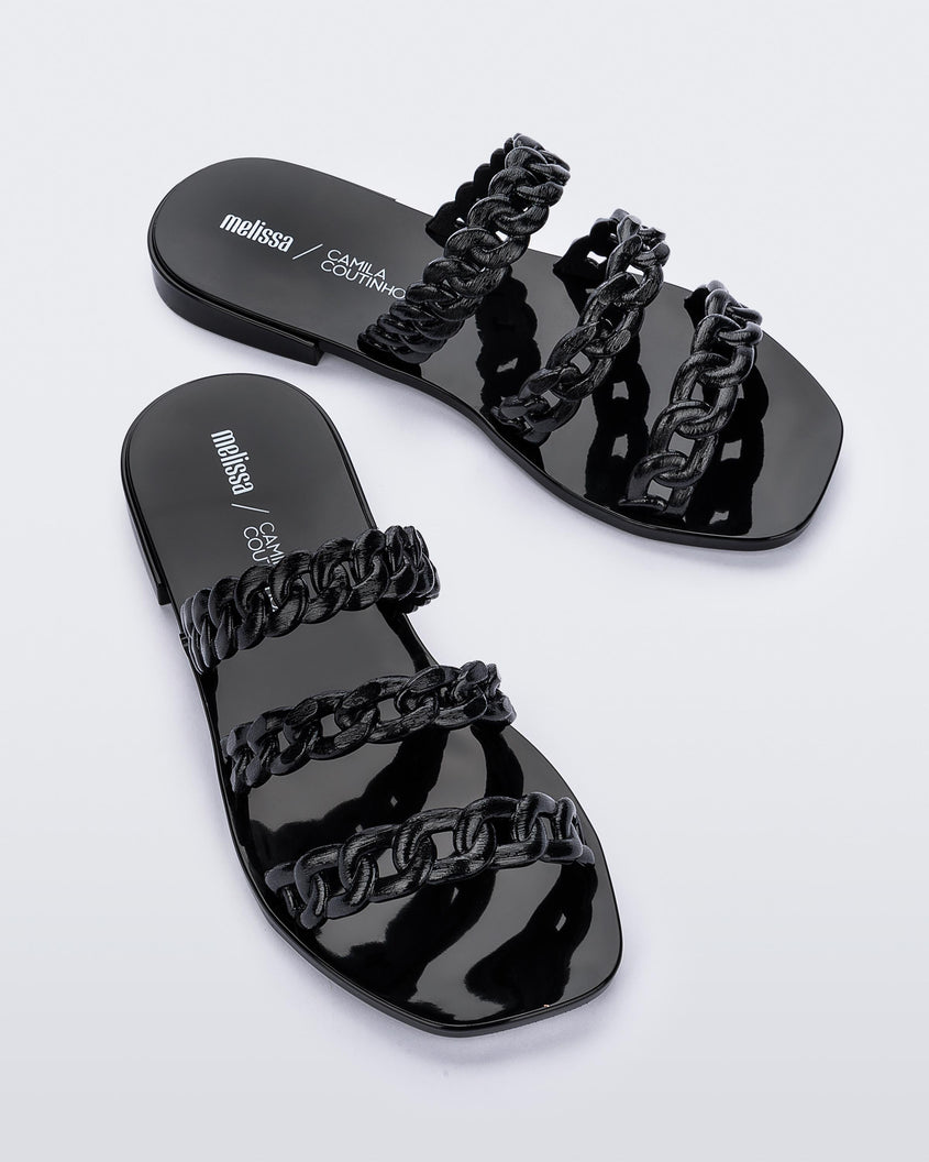 Top view of a pair of black Melissa Feel slides with three chain detail straps.