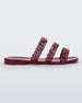 Side view of a red Melissa Feel slide with three chain detail straps.
