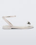 Side view of a white Melissa Dare sandal with a silver metal chain buckle.