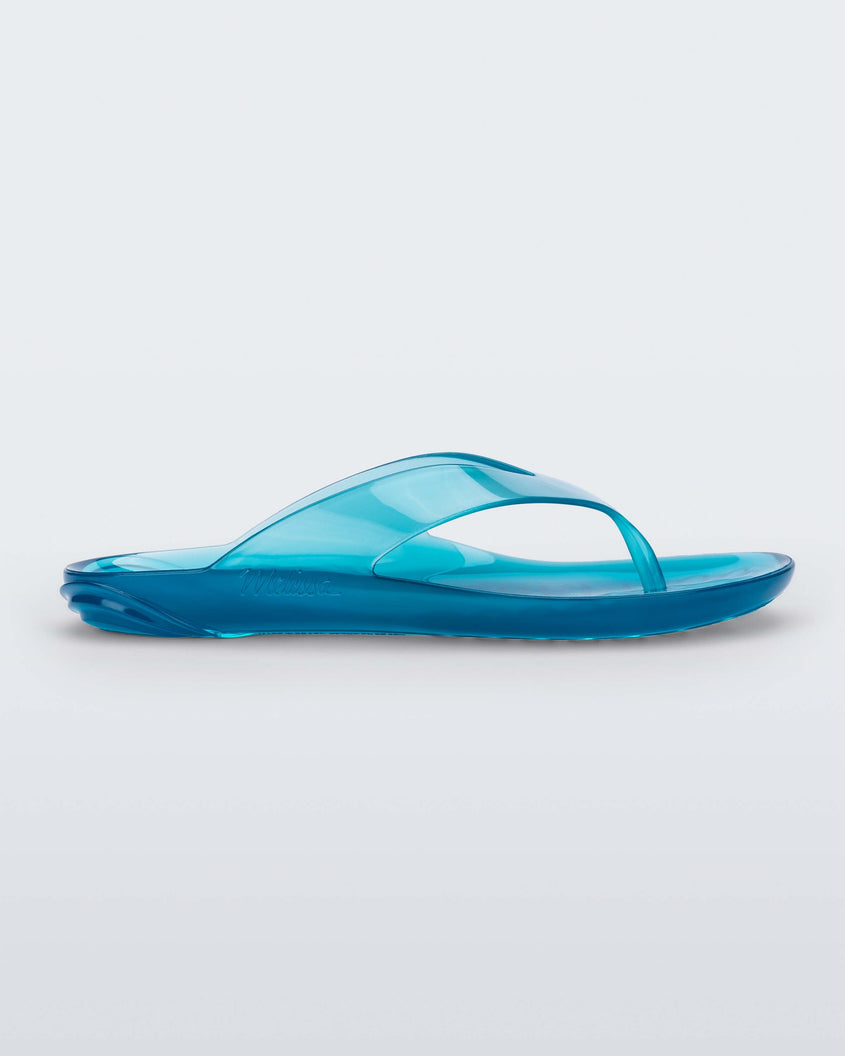 Side view of a clear blue Melissa Real Jelly Flip Flop.