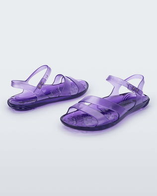 An angled front and side view of a pair of lilac Melissa Real Jelly Sandals with two front straps and an ankle strap.