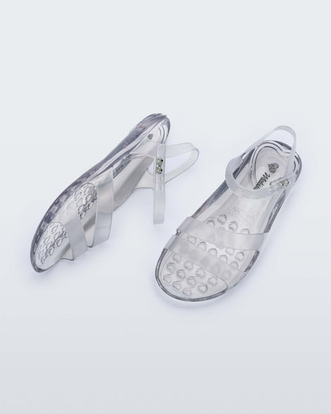 A top and side view of a pair of clear Melissa Real Jelly Sandals with two front straps and an ankle strap.