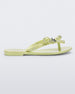 Side view of a green Mini Melissa Harmonic Stars flip flop with a bow and silver star details on the straps.