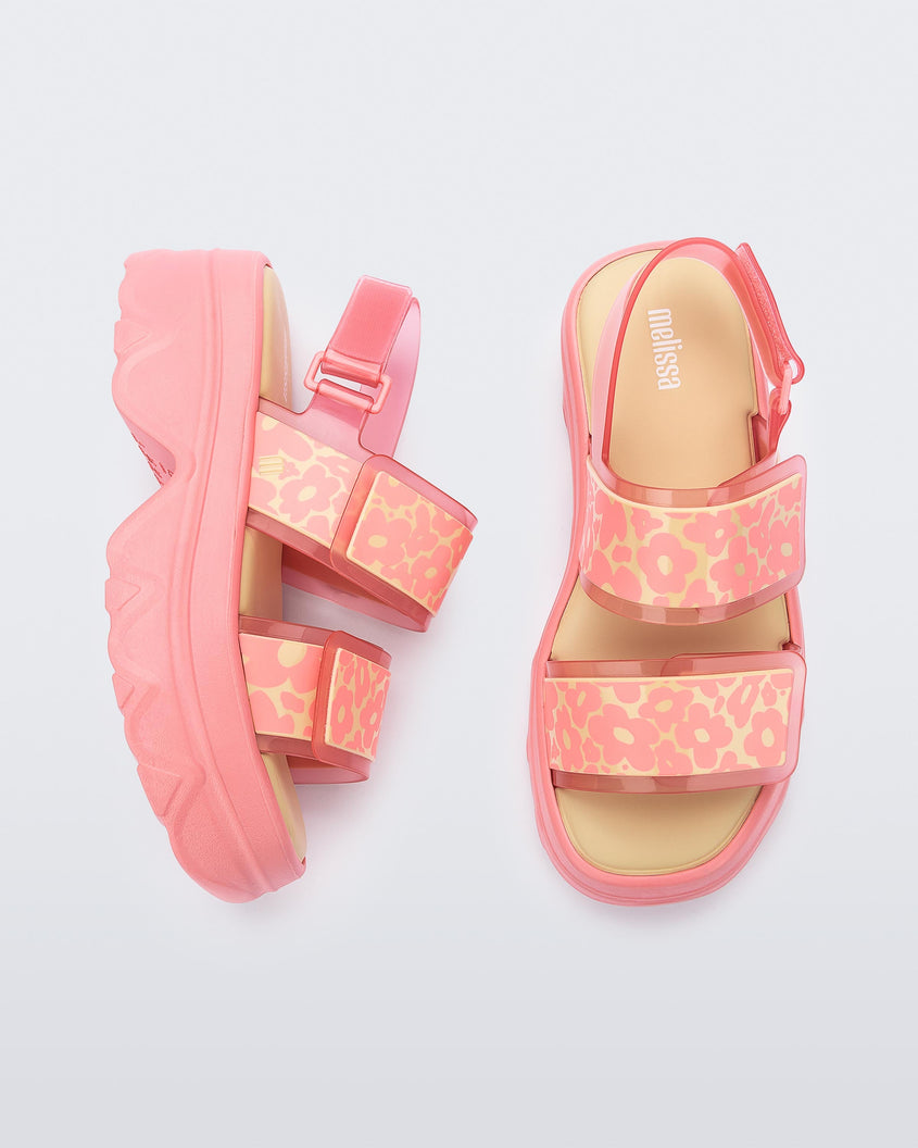 Top and side view of a pair of pink Melissa Brave Platform sandals with flower printed straps.