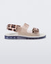 An inner side view of a clear brown Melissa Brave Papete sandals with a white insole, brown circle print, transparent beige straps and a velcro back.