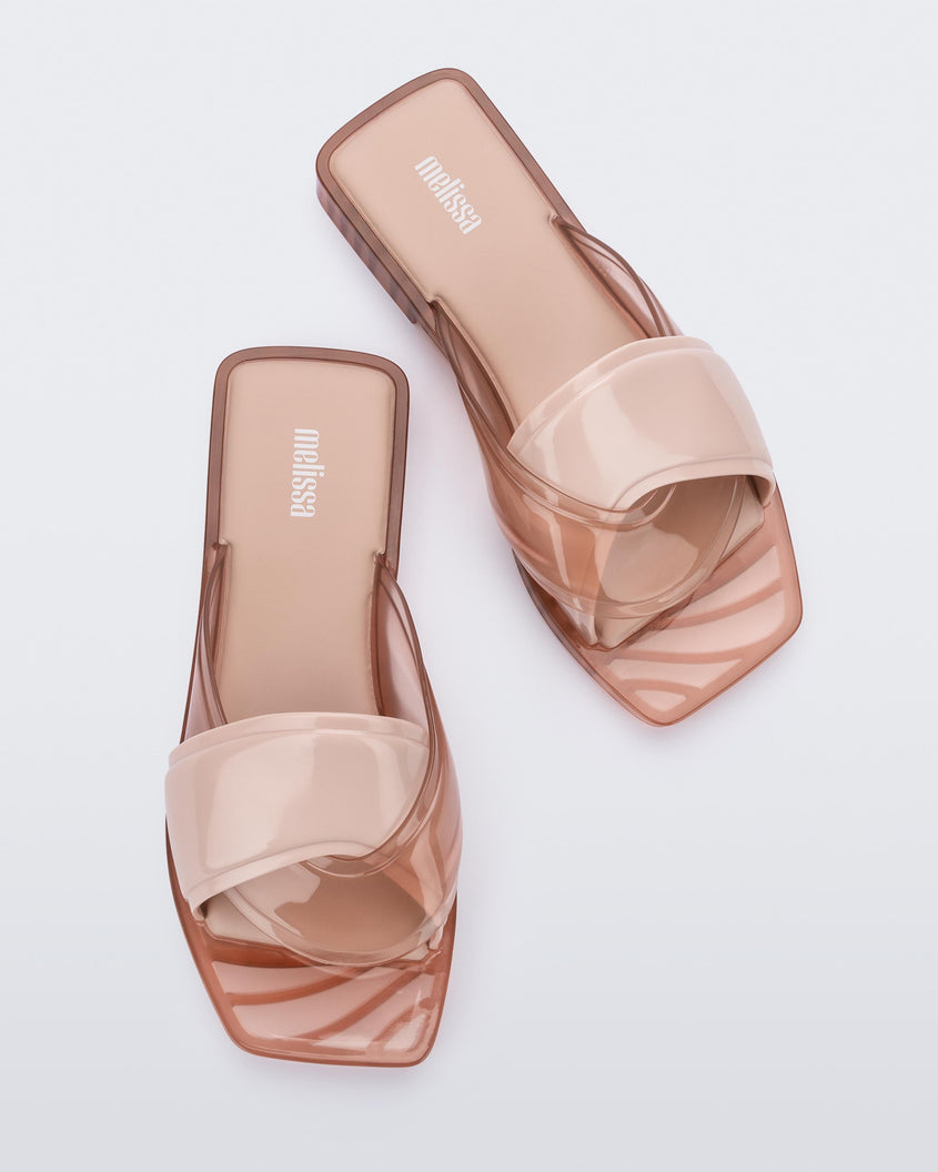 Top view of a pair of pink Melissa Brigitte slides with a solid and transparent weft designed upper strap.