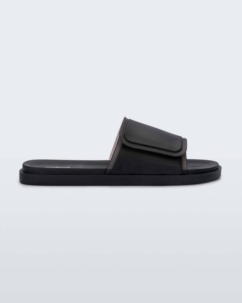 Side view of a black Melissa Brave Slide with a black velcro top strap and black insole.