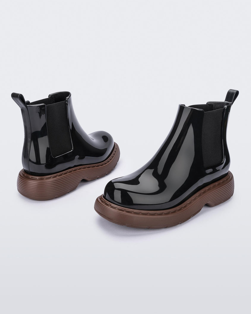 Front and back view of a pair of Melissa Step slip on ankle boots with bronze sole and black upper.