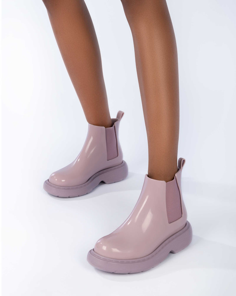 Model's legs wearing a pair of Melissa Step slip on ankle boots in Lilac with lug sole. 