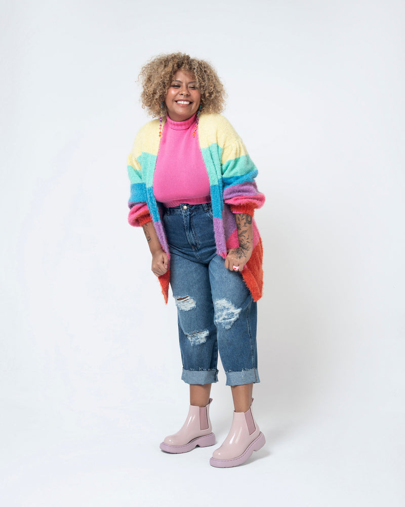 Model posing in jeans and a pink sweater wearing a pair of Melissa Step slip on ankle boots in Lilac with lug sole. 
