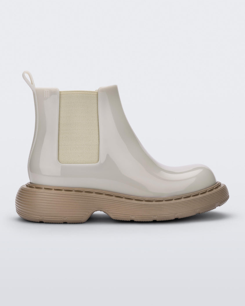 Side view of a Melissa Step slip on ankle boot with beige upper and brown lugg sole 