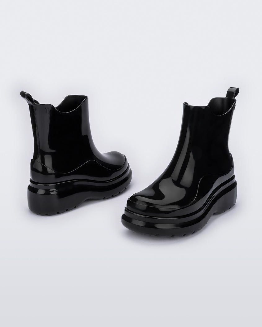 An angled side and front view of a pair of black Melissa Grip short rain boots.