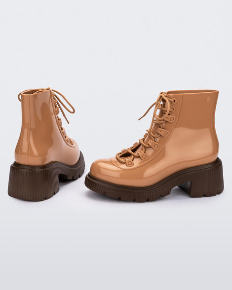 A back and side view of a pair of bronze/beige Melissa Cosmo boots with a bronze/beige base, laces and a brown heel sole.