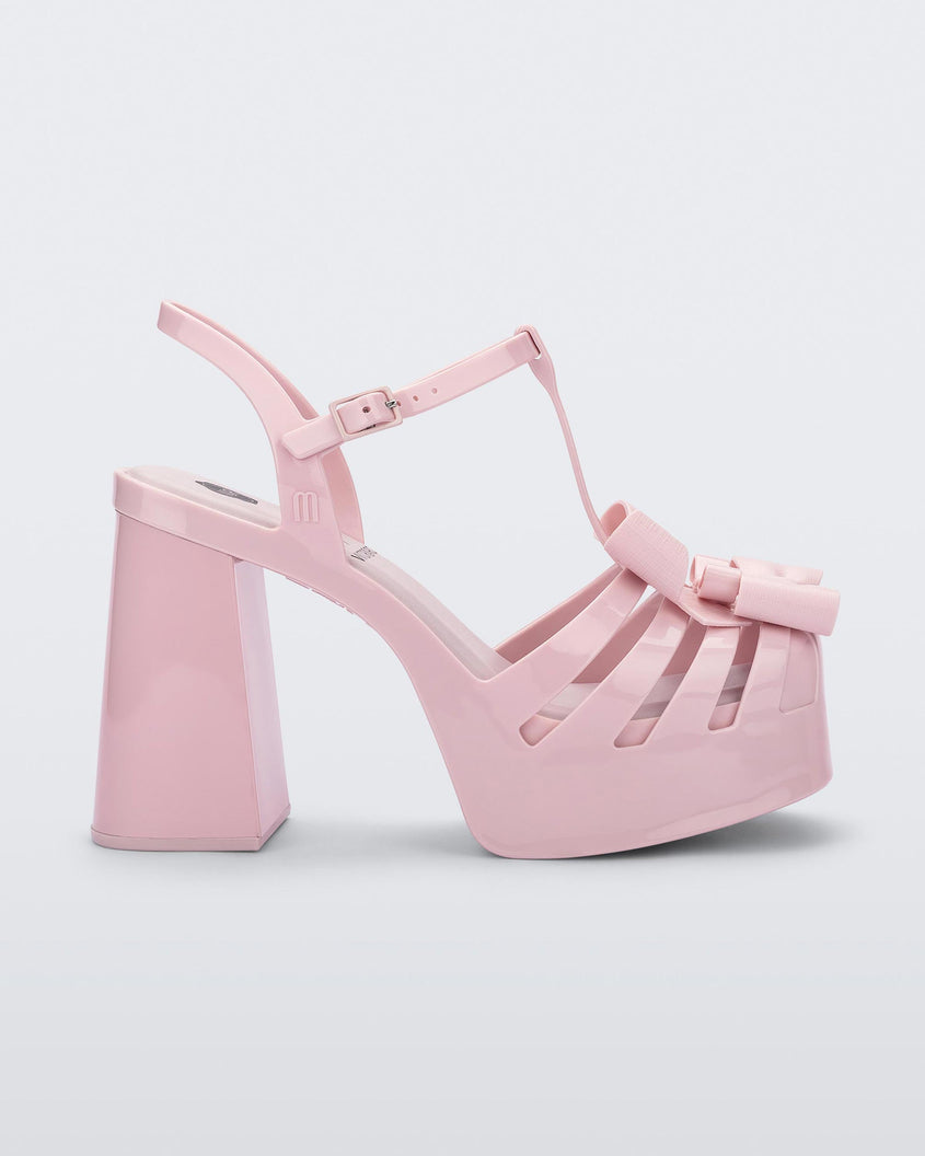 Side view of a Melissa Tie Party platform heel in Pink with 3D bow detail and ankle strap with buckle. 