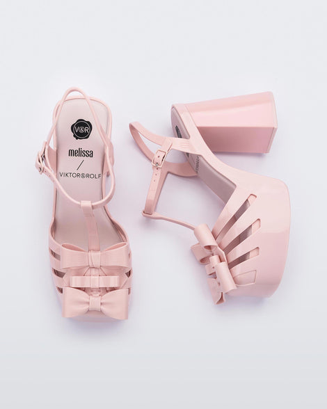 Top and side view of a pair of Melissa Tie Party platform heels in Pink with 3D bow detail and ankle strap with buckle. 