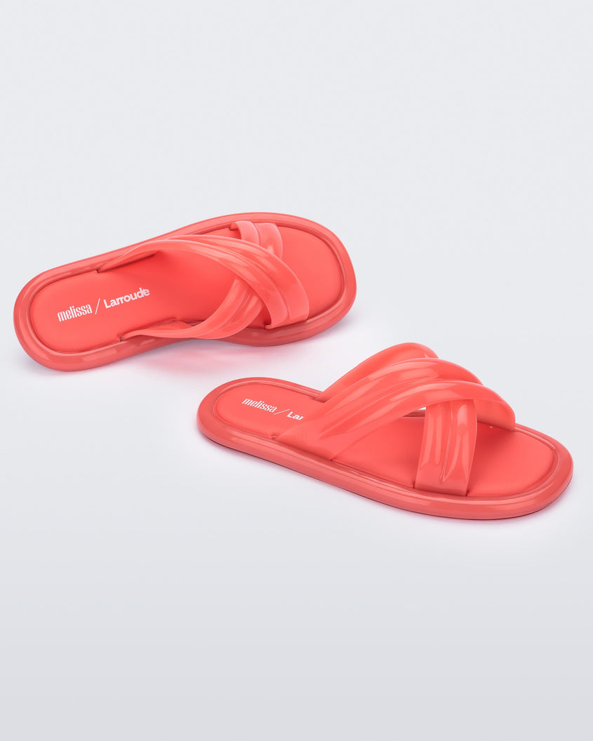 Top and angled view of a pair of red Melissa Cali slides with cross straps.