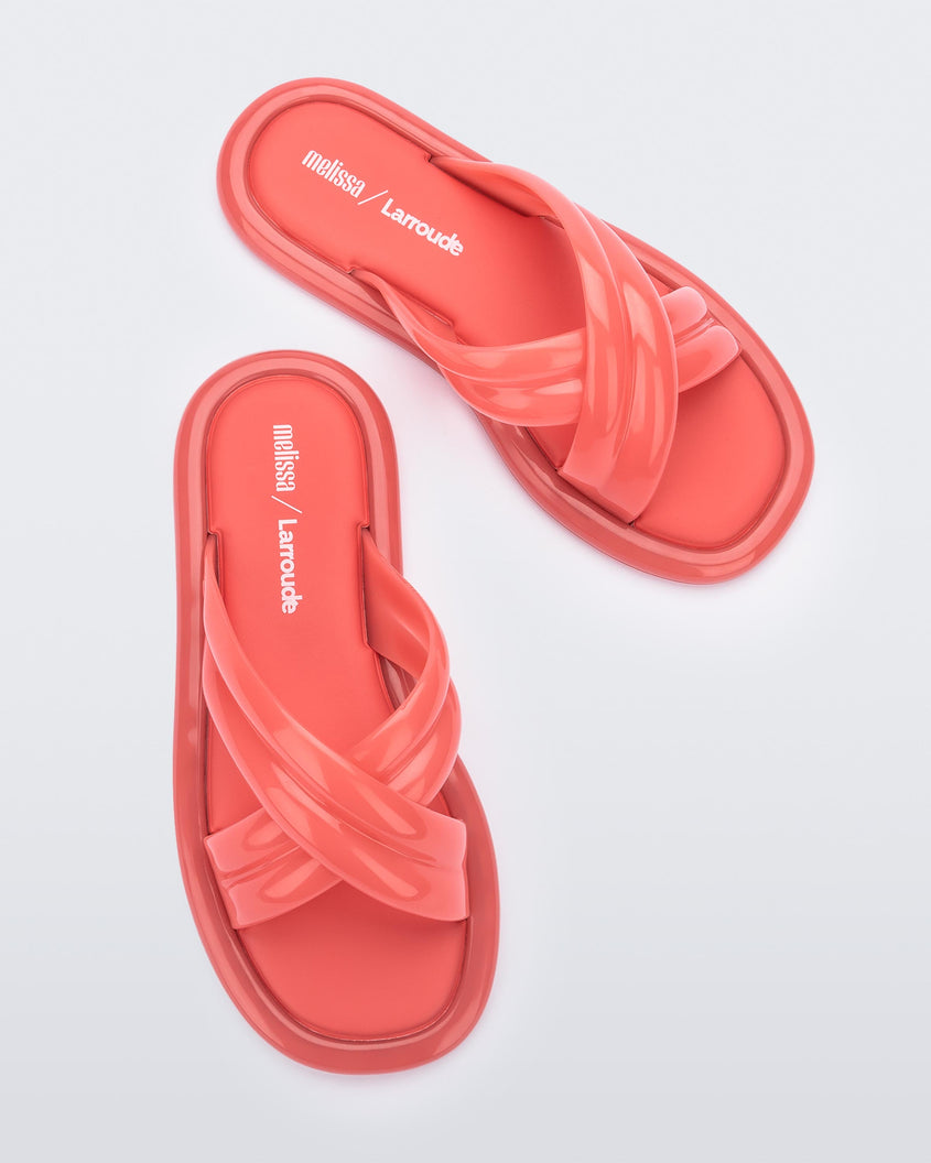 Top view of a pair of red Melissa Cali slides with cross straps.