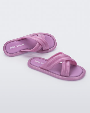 Top and angled view of a pair of lilac Melissa Cali slides with cross straps.